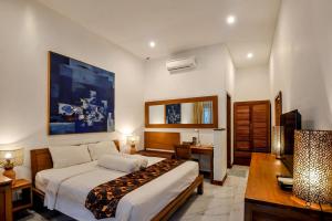 a hotel room with a bed and a desk and a bed sidx sidx sidx sidx at Rumah Mertua Heritage in Yogyakarta