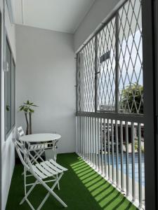 un balcone con tavolo e sedia su un pavimento verde di Muji Designer Suite a Jeram