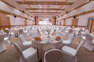 un gran salón de banquetes con mesas blancas y sillas blancas en Asia Airport Hotel en Bangkok
