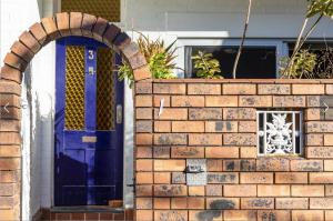 a brick wall with a blue door on a house at Sunny Apartment in Surry Hills in Sydney