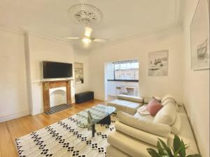 a living room with a white couch and a fireplace at Sunny Apartment in Surry Hills in Sydney
