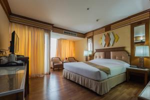 a hotel room with a bed and a television at Asia Airport Hotel in Bangkok