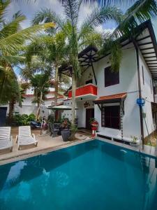 a villa with a swimming pool in front of a house at Luxury villa Costanza in Hikkaduwa