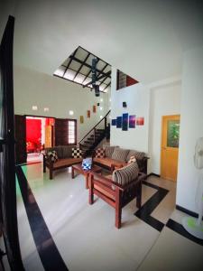 a living room with two couches and a staircase at Luxury villa Costanza in Hikkaduwa