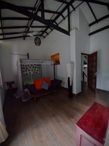 a living room with a couch and a wooden floor at Luxury villa Costanza in Hikkaduwa