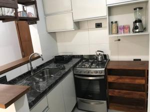 una pequeña cocina con fogones y fregadero en Moderno departamento en complejo premium en Córdoba