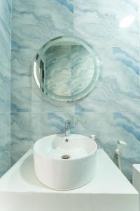y baño con lavabo blanco y espejo. en Homestay Bảo Châu - Nhơn Lý Quy Nhơn, en Quy Nhon