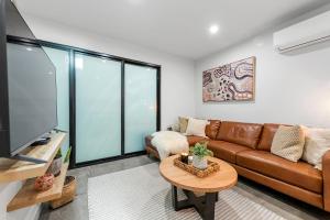 a living room with a couch and a table at Self Contained Loft Apartment in CBD in Devonport