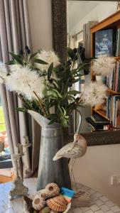 a vase filled with white flowers on a table at Boutique Art Retreat in Upper Hutt
