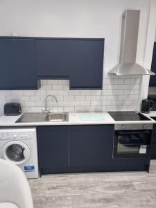 a kitchen with a sink and a washing machine at Doll Apartment in Montrose