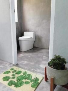 a bathroom with a toilet and a potted plant at Farm House kohyaoyai in Ko Yao Yai