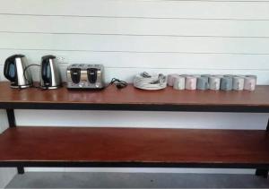 uma mesa de madeira com chávenas de café e electrodomésticos em Farm House kohyaoyai em Ko Yao Yai