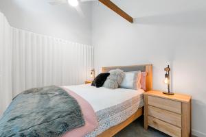 Self Contained Loft Apartment in CBD في ديفونبورت: غرفة نوم عليها سرير مع كلب
