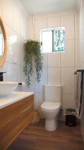 łazienka z toaletą, umywalką i oknem w obiekcie Petit Manor w mieście Cromer