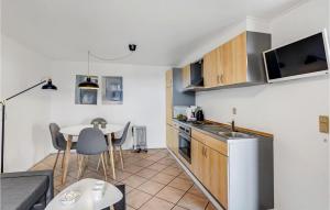 uma cozinha com uma mesa e uma pequena cozinha com uma mesa em 1 Bedroom Awesome Apartment In Hjer em Højer