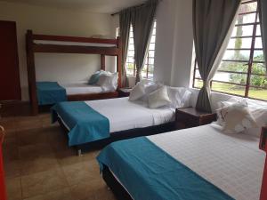 pokój hotelowy z 2 łóżkami i oknami w obiekcie Finca Hotel Villa Clara w mieście Chinchiná