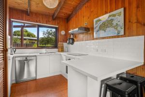 a kitchen with a white counter and a sink at Philippas Paddock in Cowes +5 photos