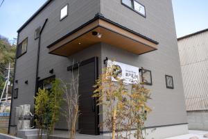 a building with a black door with a sign on it at Second Home 瀬戸風月 in Takamatsu