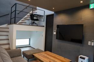a living room with a flat screen tv on a wall at Second Home 瀬戸風月 in Takamatsu