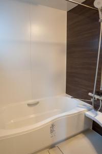 a white bath tub with a glass window in a bathroom at Second Home 瀬戸風月 in Takamatsu