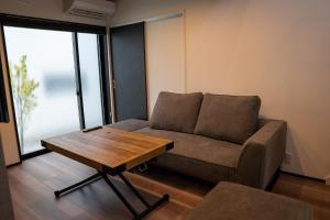 a living room with a couch and a coffee table at Second Home 瀬戸風月 in Takamatsu