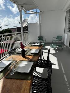 a wooden table and chairs on a balcony at Pomme Surette in Sainte-Anne