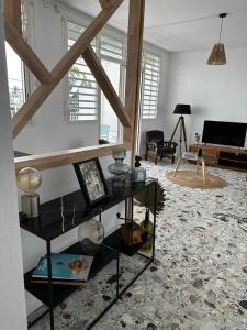a living room with a black shelf in a room with a piano at Pomme Surette in Sainte-Anne
