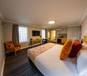 a hotel room with a large bed and a desk at Potters Toowoomba Hotel in Toowoomba
