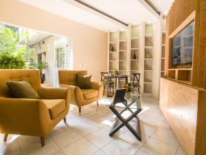 een woonkamer met gele stoelen en een tv bij CASA NIAGARA in Mexico-Stad
