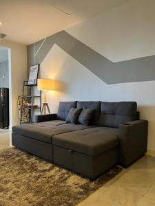 ein großes Sofa in einem Wohnzimmer mit einer Decke in der Unterkunft Imperio Residences Private Bathtub or Jacuzzi by Nestcove in Malakka