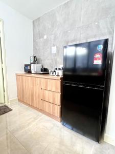 eine Küche mit einem schwarzen Kühlschrank und einer Theke in der Unterkunft Imperio Residences Private Bathtub or Jacuzzi by Nestcove in Malakka