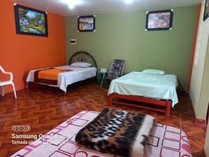 a room with two beds and a rug at Casa Hospedaje San Miguel in Trujillo