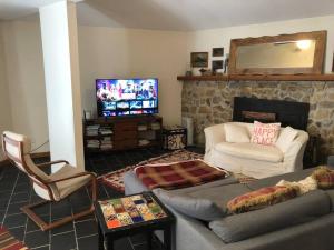 uma sala de estar com um sofá e uma televisão em Spacious Pocono Getaway - Castle Blackberry em Jim Thorpe