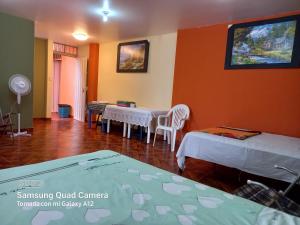 Habitación con 2 camas, mesa y sillas en Casa Hospedaje San Miguel, en Trujillo