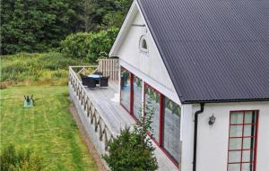 a white house with a deck with a table on it at Pet Friendly Home In Laholm With Wifi in Laholm