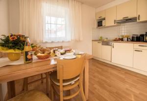 a kitchen with a wooden table with a bottle of wine at Ferienwohnung Wörthsee in Herrsching am Ammersee