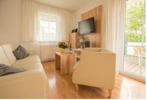 ein Wohnzimmer mit einem Sofa und einem TV in der Unterkunft Ferienwohnung Wörthsee in Herrsching am Ammersee