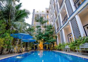 贡布Kampot View Boutique的一座带蓝色遮阳伞的建筑中的游泳池
