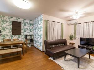 una sala de estar con un sofá y una mesa en Ocean Front Maezato, en Ishigaki Island
