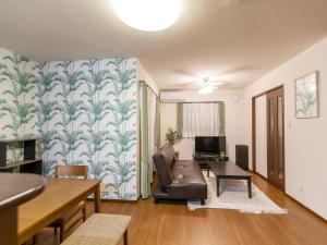 una sala de estar con un sofá y una mesa en Ocean Front Maezato, en Ishigaki Island