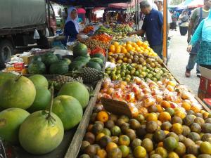 a market with a variety of fruits and vegetables on display at IZ Budget in Kampung Kuala Besut
