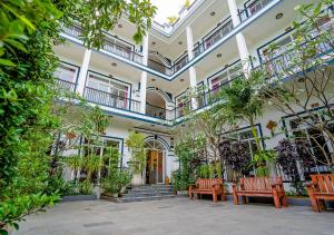 a building with benches and plants in a courtyard at Kampot View Boutique in Kampot