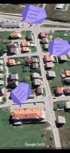 a group of houses in a yard with purple signs at Apartman Cypres in Kupres