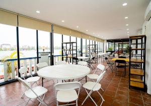 a room with tables and chairs and windows at Kampot View Boutique in Kampot