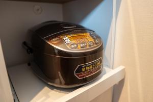 a slow cooker sitting on a shelf in a room at Second Home 瀬戸風月 in Takamatsu