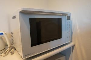 a microwave oven sitting on top of a shelf at Second Home 瀬戸風月 in Takamatsu