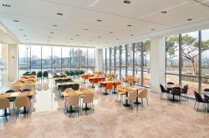 een eetkamer met tafels, stoelen en ramen bij ibis Styles Ambassador Incheon Airport T2 in Incheon