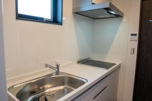 a kitchen with a sink and a window above it at Second Home 瀬戸風月 in Takamatsu
