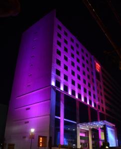 - un bâtiment avec des lumières violettes la nuit dans l'établissement E Hotel, à Chennai