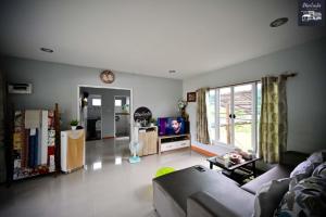 ein Wohnzimmer mit einem Sofa und einem TV in der Unterkunft มีจันทร์เขาค้อ in Ban Thung Samo